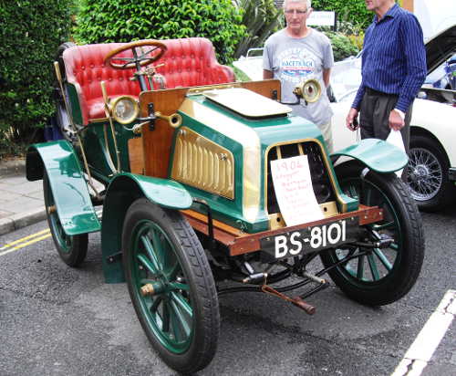 a vintage car painted green and gold with red upholstery
